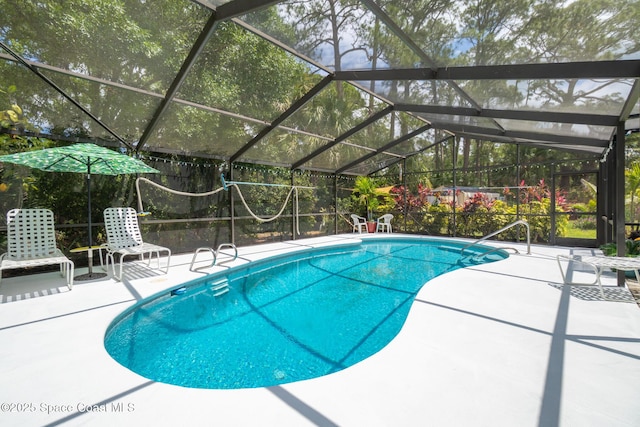 pool with glass enclosure and a patio area