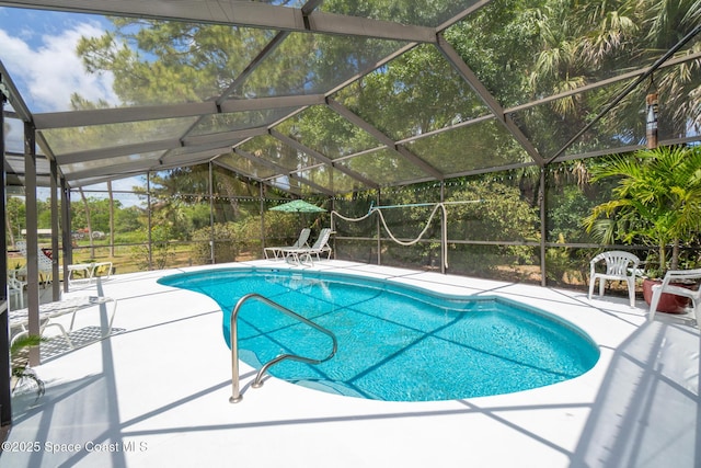 outdoor pool featuring glass enclosure and a patio area