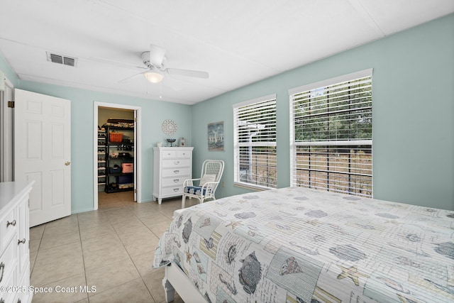 bedroom with visible vents, a closet, ceiling fan, a spacious closet, and light tile patterned floors