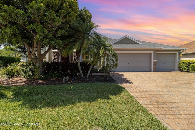 3196 Quint Dr, Melbourne, FL 32940 - view of front of home with decorative driveway, an attached garage, stucco siding, a front lawn, and roof with shingles
