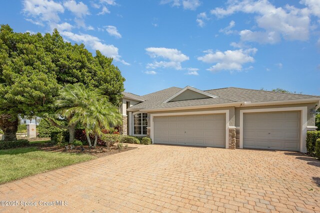 3196 Quint Dr, Melbourne, FL 32940 - view of front of property with stone siding, stucco siding, driveway, an attached garage, and a shingled roof