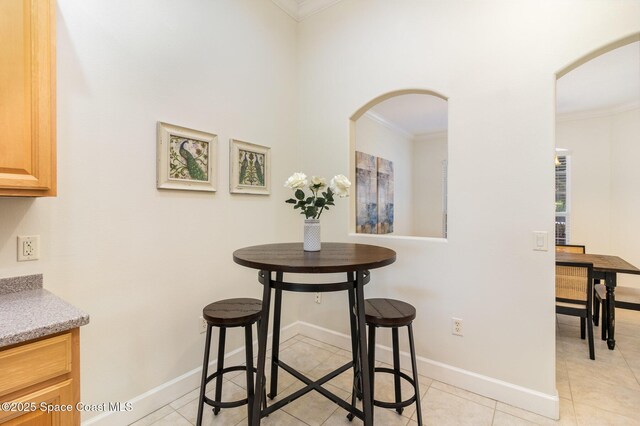 3196 Quint Dr, Melbourne, FL 32940 - dining space featuring arched walkways, ornamental molding, baseboards, and light tile patterned floors