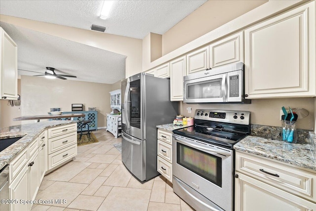 6280 Golfview Ave, Cocoa, FL 32927 - kitchen featuring light stone countertops, ceiling fan, a textured ceiling, stainless steel appliances, and visible vents