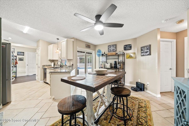 6280 Golfview Ave, Cocoa, FL 32927 - kitchen featuring ceiling fan, a sink, a textured ceiling, stainless steel appliances, and white cabinetry