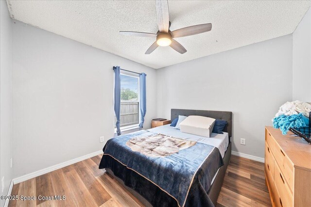 6280 Golfview Ave, Cocoa, FL 32927 - bedroom with baseboards, a ceiling fan, a textured ceiling, and wood finished floors