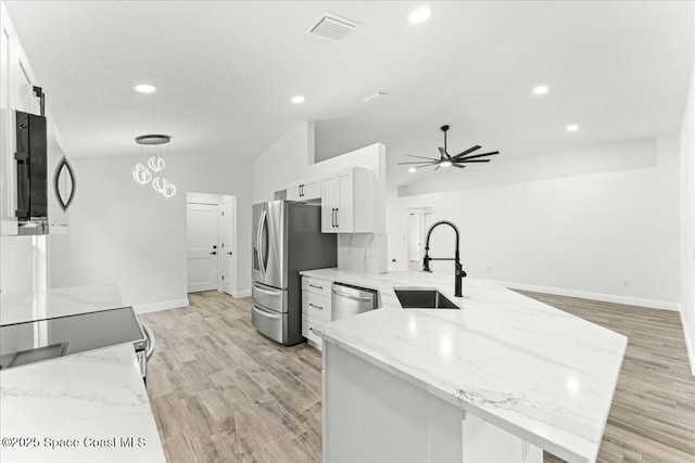 3871 La Flor Dr, Rockledge, FL 32955 - kitchen with a peninsula, stainless steel appliances, a sink, visible vents, and white cabinetry