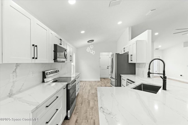 3871 La Flor Dr, Rockledge, FL 32955 - kitchen featuring vaulted ceiling, visible vents, a sink, tasteful backsplash, and appliances with stainless steel finishes
