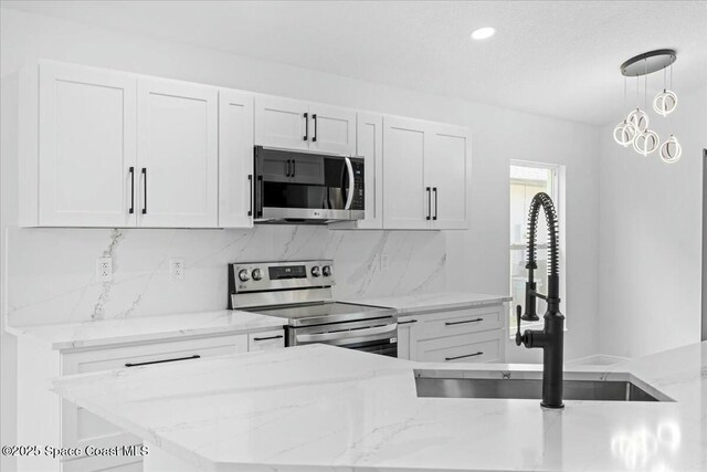 3871 La Flor Dr, Rockledge, FL 32955 - kitchen featuring tasteful backsplash, a sink, white cabinets, appliances with stainless steel finishes, and light stone countertops