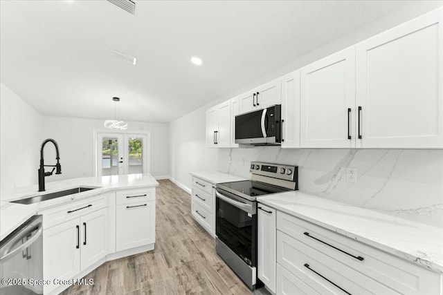 3871 La Flor Dr, Rockledge, FL 32955 - kitchen with white cabinets, french doors, stainless steel appliances, and a sink