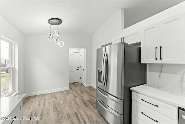 3871 La Flor Dr, Rockledge, FL 32955 - kitchen featuring white cabinets, light stone counters, light wood-style floors, pendant lighting, and stainless steel refrigerator with ice dispenser