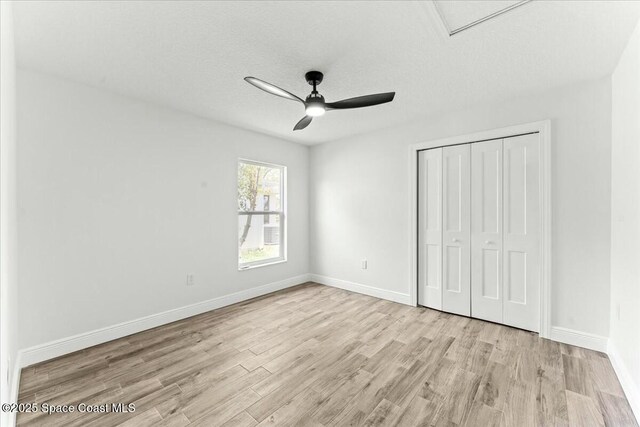 3871 La Flor Dr, Rockledge, FL 32955 - unfurnished bedroom with baseboards, wood finished floors, a textured ceiling, and a closet