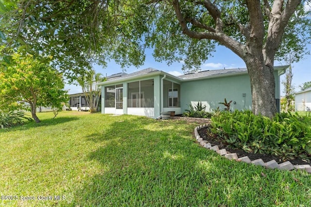 3871 La Flor Dr, Rockledge, FL 32955 - back of house with a sunroom, stucco siding, and a lawn