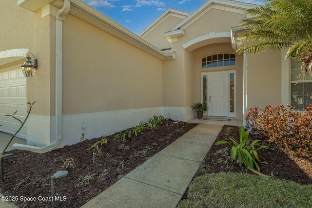 5334 Creekwood Dr, Melbourne, FL 32940 - property entrance featuring an attached garage and stucco siding
