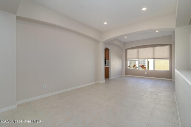 5334 Creekwood Dr, Melbourne, FL 32940 - empty room with light tile patterned floors, baseboards, recessed lighting, and arched walkways