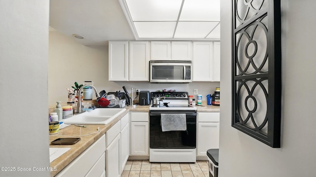 3050 Sir Hamilton Cir Unit 2, Titusville, FL 32780 - kitchen featuring stainless steel microwave, range with electric cooktop, a sink, white cabinetry, and light countertops