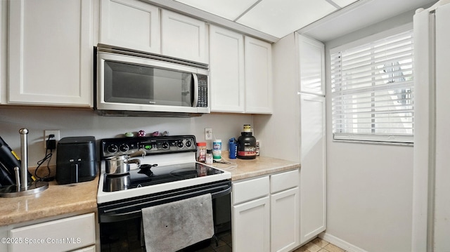 3050 Sir Hamilton Cir Unit 2, Titusville, FL 32780 - kitchen with electric range oven, stainless steel microwave, light countertops, and white cabinets