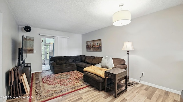 3050 Sir Hamilton Cir Unit 2, Titusville, FL 32780 - living area featuring light wood-style floors, baseboards, and a textured ceiling