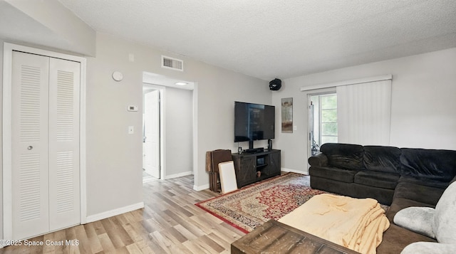 3050 Sir Hamilton Cir Unit 2, Titusville, FL 32780 - living area featuring wood finished floors, a textured ceiling, and baseboards