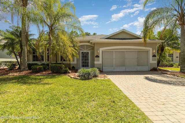 439 Gardendale Cir SE, Palm Bay, FL 32909 - view of front of house with an attached garage, a front yard, decorative driveway, and stucco siding