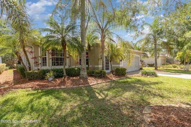 439 Gardendale Cir SE, Palm Bay, FL 32909 - view of front facade featuring concrete driveway, a front lawn, stucco siding, and a garage