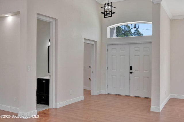 2742 Fling Ave SE, Palm Bay, FL 32909 - foyer featuring a chandelier, a towering ceiling, light wood finished floors, baseboards, and ornamental molding
