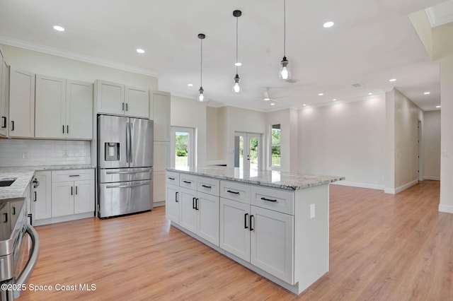 2742 Fling Ave SE, Palm Bay, FL 32909 - kitchen featuring decorative backsplash, stainless steel refrigerator with ice dispenser, a kitchen island, and ornamental molding