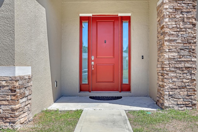 doorway to property featuring stucco siding