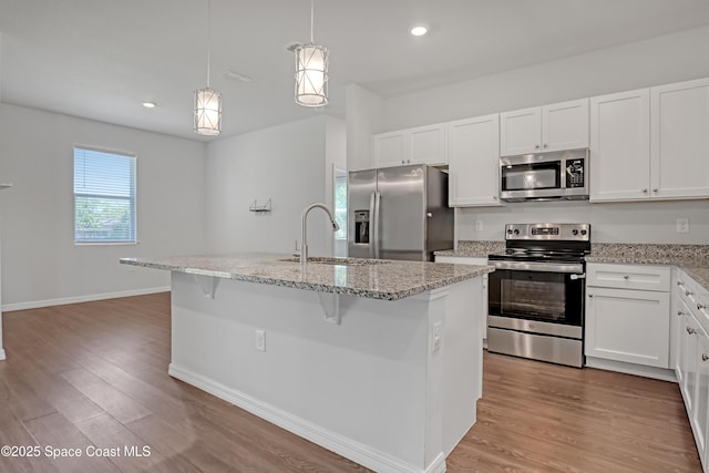 kitchen with white cabinetry, a sink, light wood-style floors, and appliances with stainless steel finishes