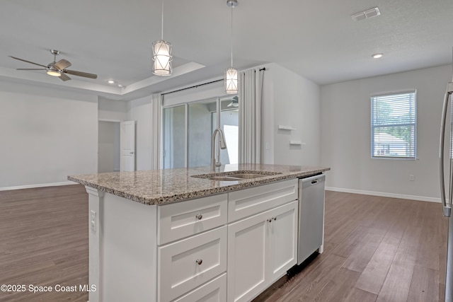 kitchen with visible vents, wood finished floors, dishwashing machine, and a sink