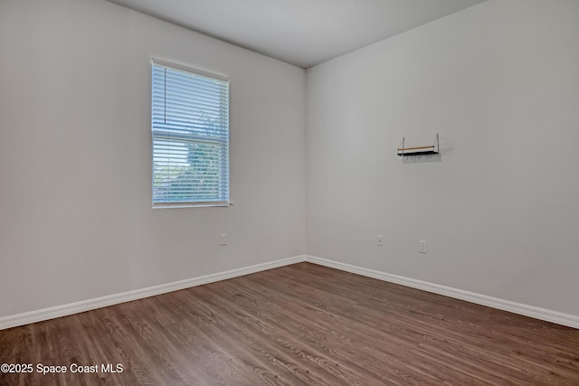 empty room featuring baseboards and wood finished floors