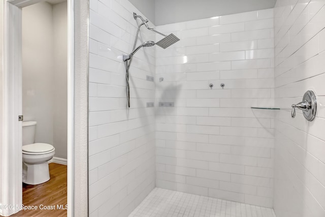 bathroom featuring a stall shower, wood finished floors, and toilet