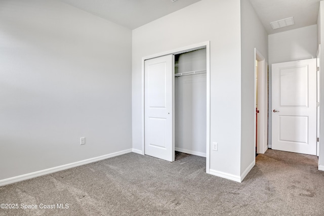 unfurnished bedroom featuring baseboards, carpet, and a closet