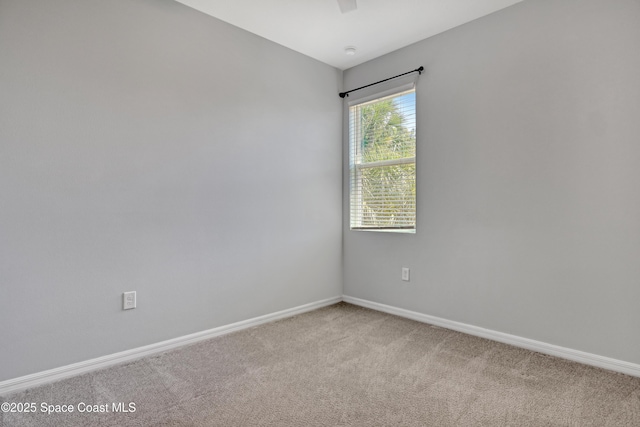 unfurnished room featuring light carpet and baseboards