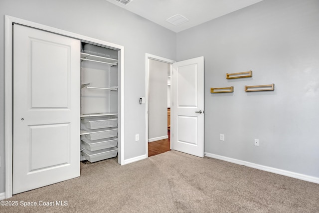 unfurnished bedroom featuring baseboards, a closet, visible vents, and carpet