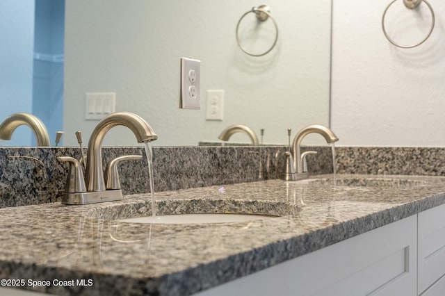 bathroom featuring a sink and double vanity
