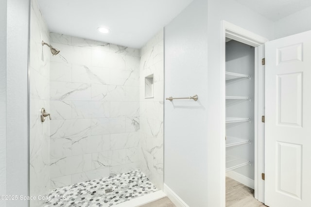 full bath with a shower stall, a walk in closet, wood finished floors, and recessed lighting