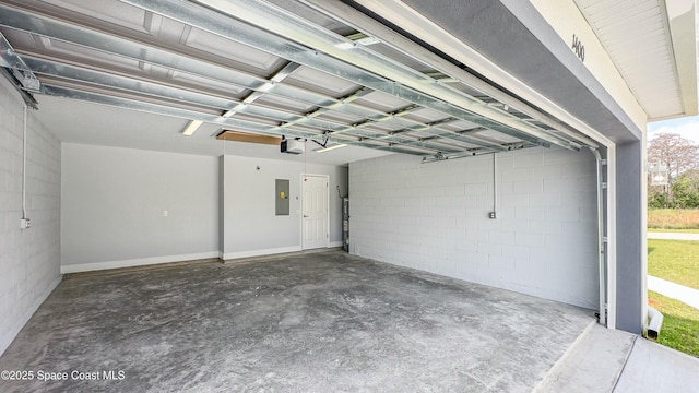 garage with concrete block wall, electric panel, and a garage door opener