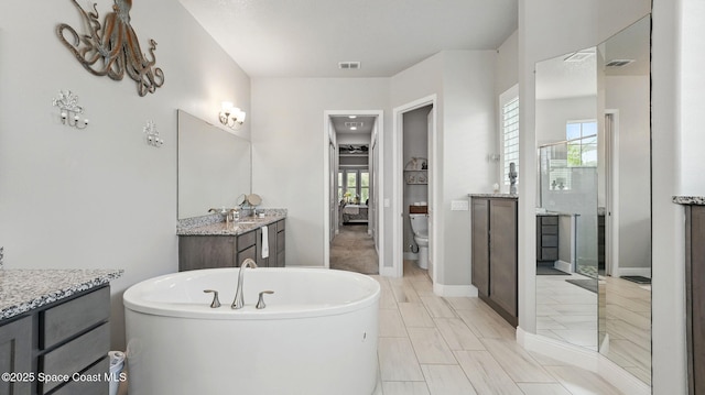 3630 Kite St, Titusville, FL 32796 - bathroom with toilet, visible vents, a freestanding tub, vanity, and a walk in shower