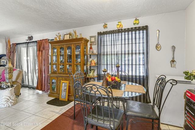 dining space with a textured ceiling and light tile patterned floors