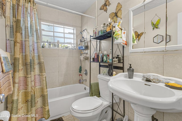 bathroom with toilet, shower / bath combo, and a sink