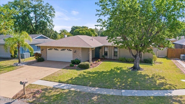 2873 Sanders Ct, Melbourne, FL 32935 - ranch-style house with fence, concrete driveway, a front lawn, and a garage