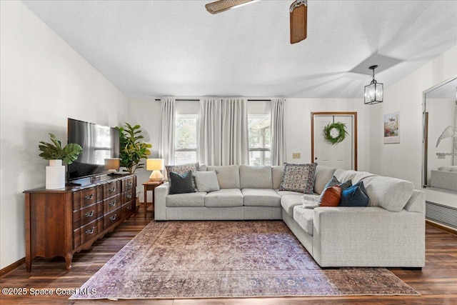 2873 Sanders Ct, Melbourne, FL 32935 - living room with baseboards, dark wood-type flooring, a textured ceiling, and ceiling fan with notable chandelier