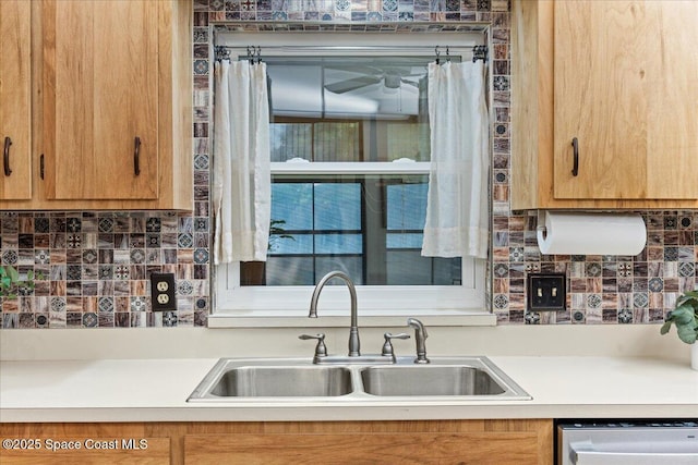 2873 Sanders Ct, Melbourne, FL 32935 - kitchen featuring light countertops, stainless steel dishwasher, decorative backsplash, and a sink