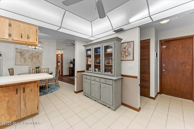 2873 Sanders Ct, Melbourne, FL 32935 - kitchen featuring visible vents, glass insert cabinets, a ceiling fan, light countertops, and light tile patterned floors