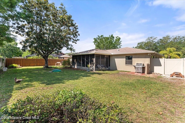 2873 Sanders Ct, Melbourne, FL 32935 - back of property featuring a yard, a sunroom, a fenced backyard, and stucco siding