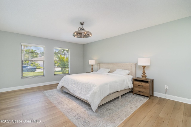 bedroom featuring baseboards and light wood-style floors