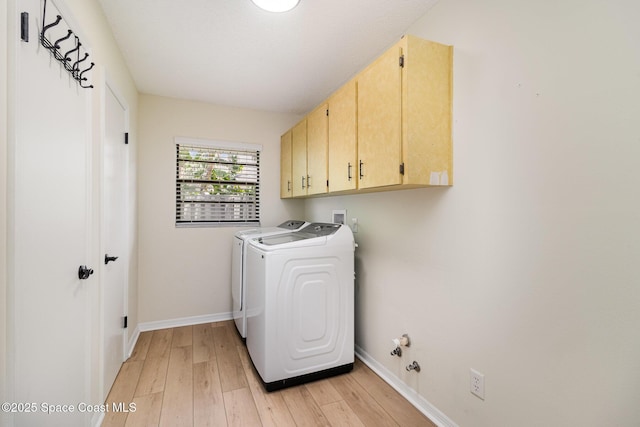 laundry room with light wood finished floors, washer and dryer, cabinet space, and baseboards