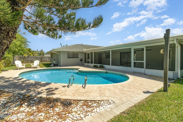 view of pool featuring a sunroom, fence, a fenced in pool, and a patio area