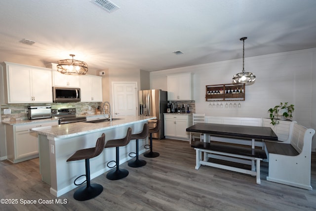 264 Moray Dr SW, Palm Bay, FL 32908 - kitchen with stainless steel appliances, backsplash, visible vents, a sink, and dark wood-style flooring