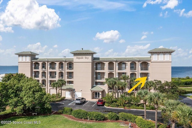 view of property featuring a water view and uncovered parking